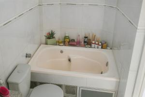 a white bathroom with a tub and a toilet at COP30 Apartment In The Center in Belém