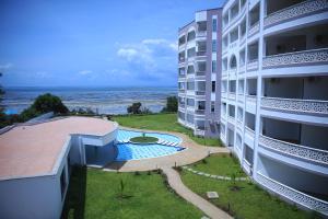 an apartment building with a swimming pool and the ocean at The Cabana at Baobab Waves in Mombasa