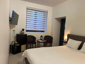 a bedroom with a bed and two chairs and a window at Ecole Buissonnière in Vielsalm +22 photos