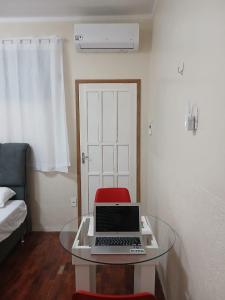 a room with a glass table with a laptop on it at Estúdio no Vieiralves in Manaus