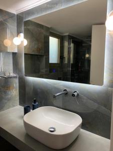 a bathroom with a white sink and a mirror at Blue Olive House & Studio in Artemida +18 photos