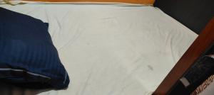 a bed with white sheets on top of it at Ashirwad Guest House in Rāmgarh