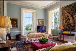 a living room with a couch and a tv at Marble Hill House in Marble Hill