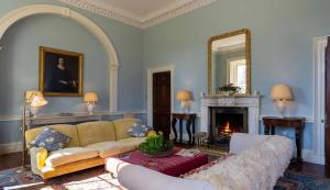 a living room with a couch and a fireplace at Marble Hill House in Marble Hill