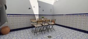 a table and chairs in a room with a tiled wall at Casa Paco & Carmela in Algodonales