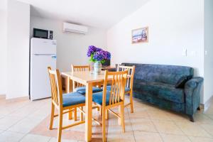 a kitchen with a table and chairs and a couch at Apartment Vir Croatia in Vir