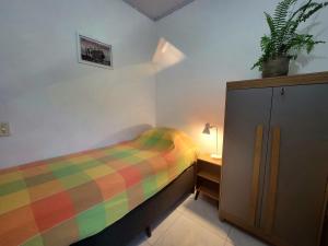 a small bedroom with a bed and a night stand at Casa na Praça de Serra Grande in Uruçuca +10 photos