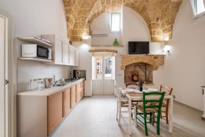 a kitchen with a table and chairs and a kitchen with a fireplace at Le Antiche Dimore in Montesano Salentino