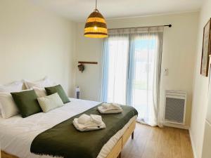 a bedroom with a large bed with two towels on it at la maison Sapanomar in Beaumes-de-Venise +36 photos