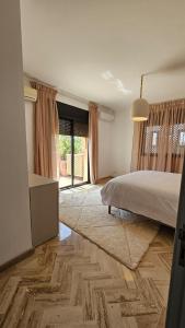 a bedroom with a bed and a large window at Votre Villa Soleil et Chaleureuse in Marrakesh +33 photos