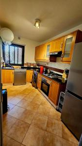 a large kitchen with wooden cabinets and appliances at Dar Hegoa Villa Soleil et Chaleureuse in Marrakech