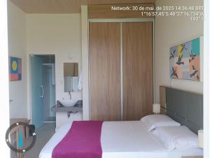 a bedroom with a large bed with a purple blanket at KAA Flat in Belém