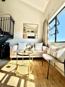 una sala de estar con un sofá y una mesa en SoftPod Loft in Prime Location Fourways, en Sandton
