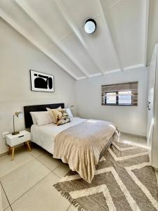 Un dormitorio con una cama grande y una alfombra. en SoftPod Loft in Prime Location Fourways, en Sandton