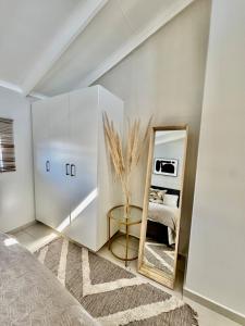 1 dormitorio con espejo y 1 cama en SoftPod Loft in Prime Location Fourways, en Sandton 10 fotos más