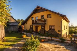 a large yellow house with a balcony on it at Pension Tofalvi in Harghita-Băi