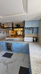 a large kitchen with blue cabinets and appliances at Quarto no apartamento do Edifício Ilha de Maui in Belém