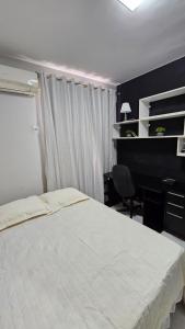 a bedroom with a bed and a desk and a desk at Quarto no apartamento do Edifício Ilha de Maui in Belém +6 photos