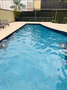 a swimming pool with blue water in a building at Quarto no apartamento do Edifício Ilha de Maui in Belém