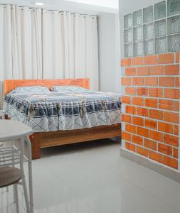 a bedroom with a bed next to a brick wall at Casa Zoilita in Pucallpa