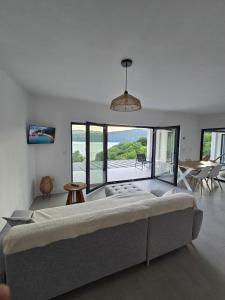 a large bed in a room with a large window at Moon Lake Bicaz - Aurora Sky in Buhalniţa