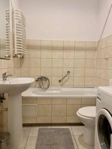 a bathroom with a tub and a sink and a toilet at Enios Rooms ul Jana kochanowskiego 26 in Kraków