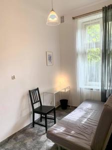 a bedroom with a couch and a chair and a window at Enios Rooms ul Jana kochanowskiego 26 in Kraków +12 photos
