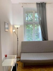 a living room with a couch and a window at Enios Rooms ul Jana kochanowskiego 26 in Kraków