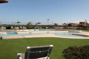 a swimming pool with a chair in the grass at Casa Sueno Dream in Playa Honda +18 photos