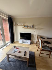 a living room with a tv and a coffee table at 2 Bedroom by JL Airport & Retail in Liverpool