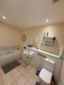 a bathroom with a sink and a tub and a toilet at 2 Bedroom by JL Airport & Retail in Liverpool +3 photos