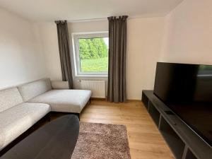 Una sala de estar con un sofá y un televisor. en geschmackvolle Wohnung in Katsdorf, modern und bequem, en Katsdorf