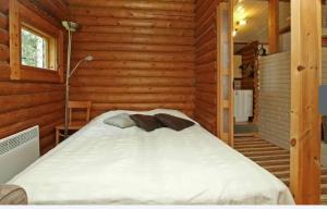 ein Schlafzimmer mit einem Bett in einer Blockhütte in der Unterkunft Seitsemisen kansallispuisto Aurejärvi Parkano in Parkano + 6 Fotos