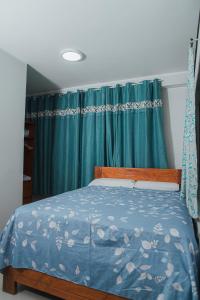 a bedroom with a bed with a blue comforter at Casa Zoilita in Pucallpa