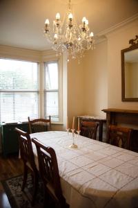 una sala da pranzo con un tavolo e un lampadario di Seaside Sanctuary in Cleethorpes, Wild Heart House a Cleethorpes