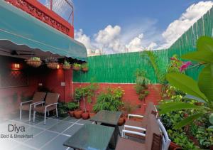 a patio with tables and chairs and plants at Diya Bed and Breakfast in New Delhi