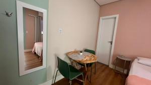a room with a table and chairs and a mirror at Boa Vista Suítes in Água Boa