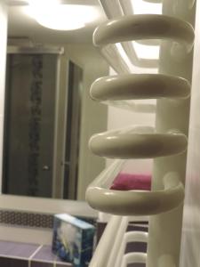 a white towel rack in front of a mirror at Apartament Violet in Krosno