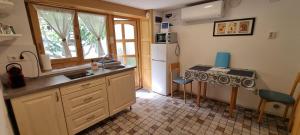 a kitchen with a sink and a table in it at Tettyei Házikó in Pécs