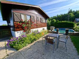a small house with a table and chairs and flowers at Le Belle Homme in Gouvy