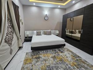 a bedroom with a large bed and a rug at SM Dream Lodges Luxury Stay in Islamabad
