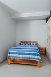a bed with a blue and white striped blanket on it at Casa Zoilita in Pucallpa +3 photos