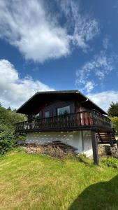 a building with a balcony on top of a grass field at Le Belle Homme in Gouvy +43 photos
