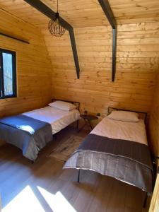 two beds in a cabin with wooden walls at Sapancalostbungalow in Feyziye +4 photos