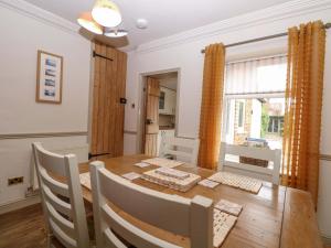 a dining room with a wooden table and chairs at Fern Cottage in Heacham +32 photos
