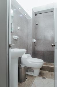 a bathroom with a white toilet and a sink at Casa Zoilita in Pucallpa