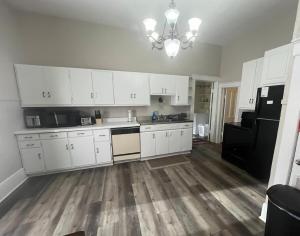 a kitchen with white cabinets and a black refrigerator at Heart City Cozy in Valentine