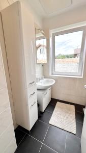 a white bathroom with a sink and a window at Das Markt 28 - Urlaub wie zu Hause in Kirchberg am Wechsel