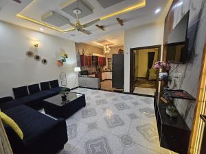 a living room with a blue couch and a kitchen at SM Dream Lodges Luxury Stay in Islamabad