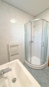 ピエシュチャニにあるComfort Central Apartment Piešťanyのシャワーと洗面台を備えた白いバスルーム +5枚の写真